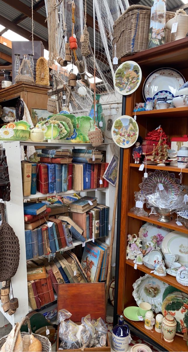 a room filled with lots of different types of dishes and baskets hanging from the ceiling