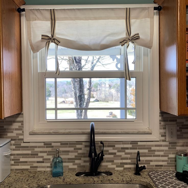 a kitchen sink under a window next to a counter