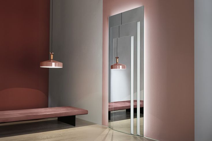 a mirror and bench in a room with pink walls, floor to ceiling mirrors and lights