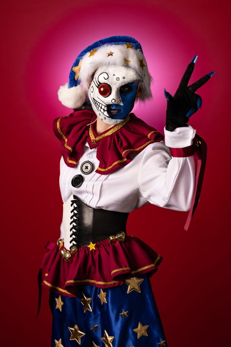 a woman dressed as a clown holding her hand up