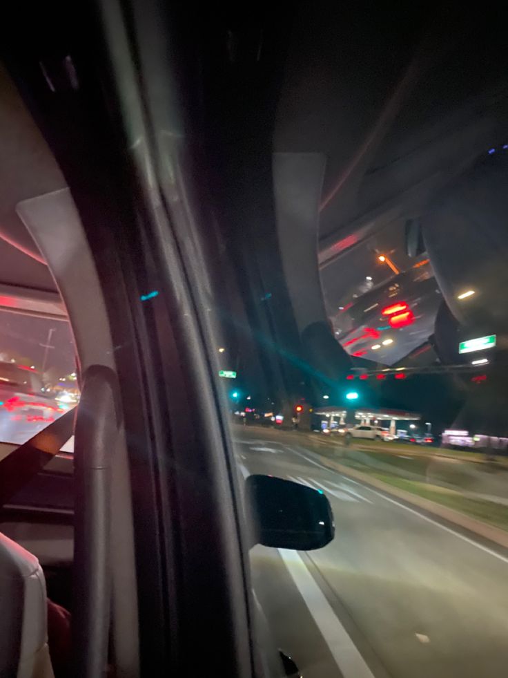 the view from inside a vehicle driving down a highway at night