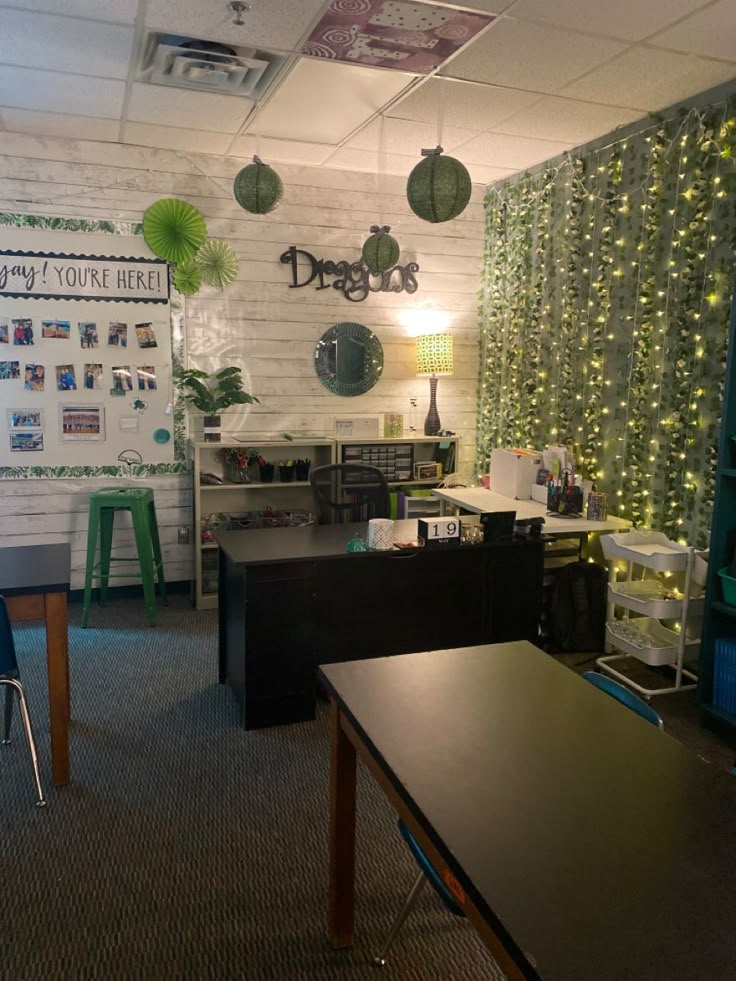 an office decorated for christmas with lights on the wall and decorations hanging from the ceiling