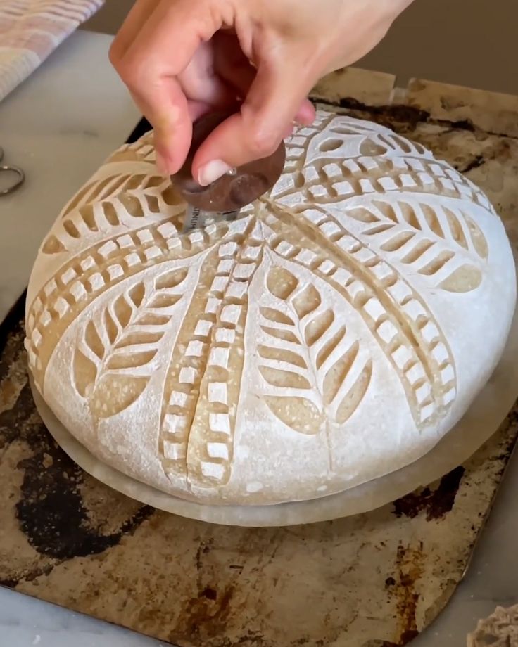 a person is carving a large piece of bread