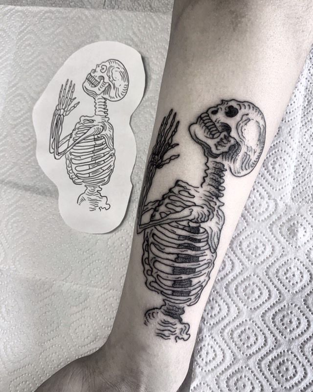 a person with a skeleton tattoo on their arm