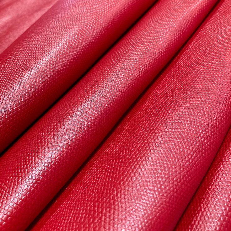 red leather textured up close to show the grains and folds that make it look like fabric