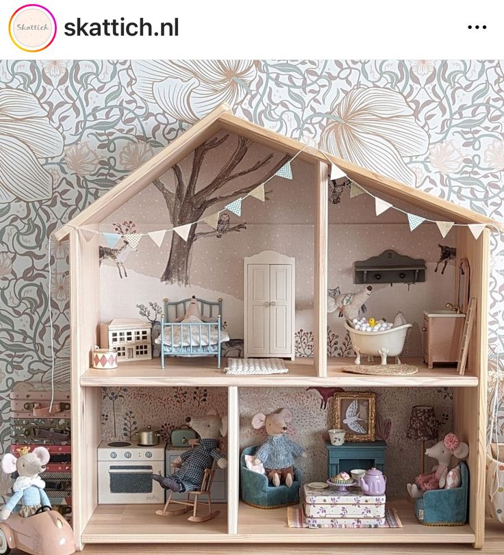 a doll house with furniture and decorations on the floor in front of a wallpapered background