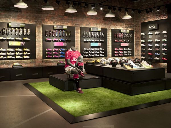 a man sitting on top of a bench in front of a display case filled with shoes