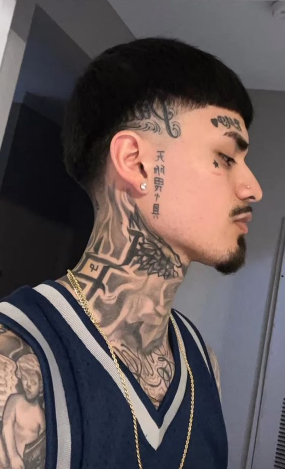 a man with tattoos on his face and neck