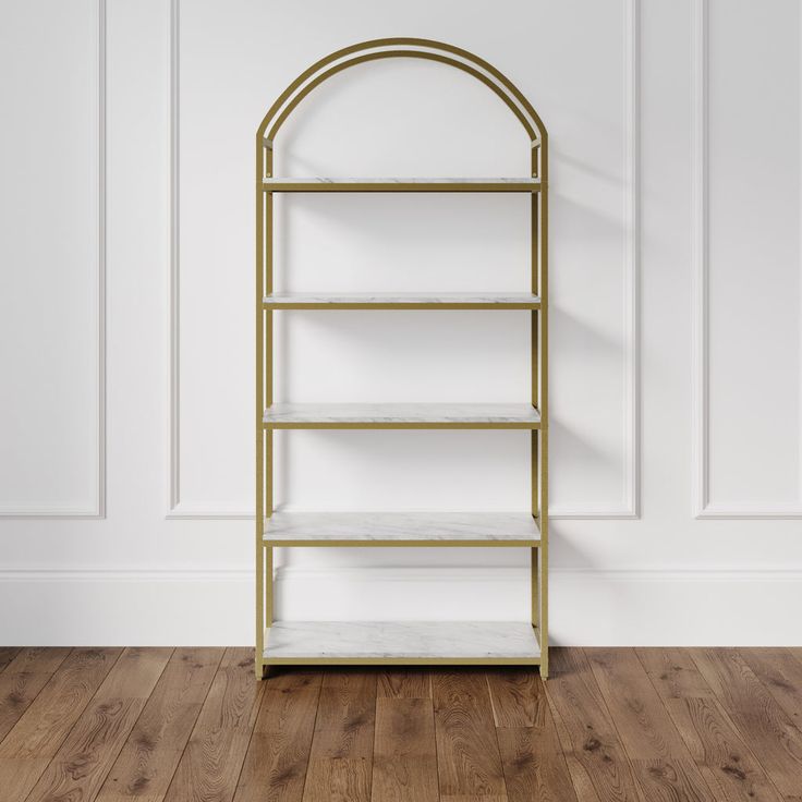 a white and gold book shelf against a wall with wood flooring in an empty room