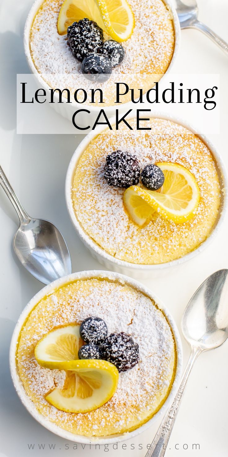 two lemon pudding cakes with powdered sugar and fresh berries on top, served in white bowls