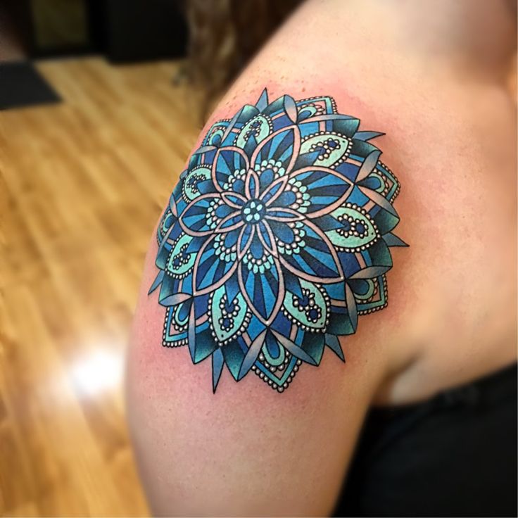 a woman's arm with a tattoo on it that has a blue flower design