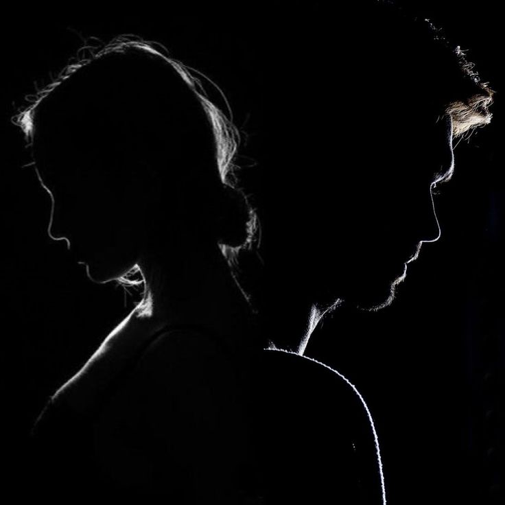 the silhouette of two people are shown against a black background