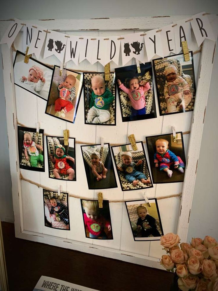 a bunch of pictures hanging on a clothes line with some flowers in front of it