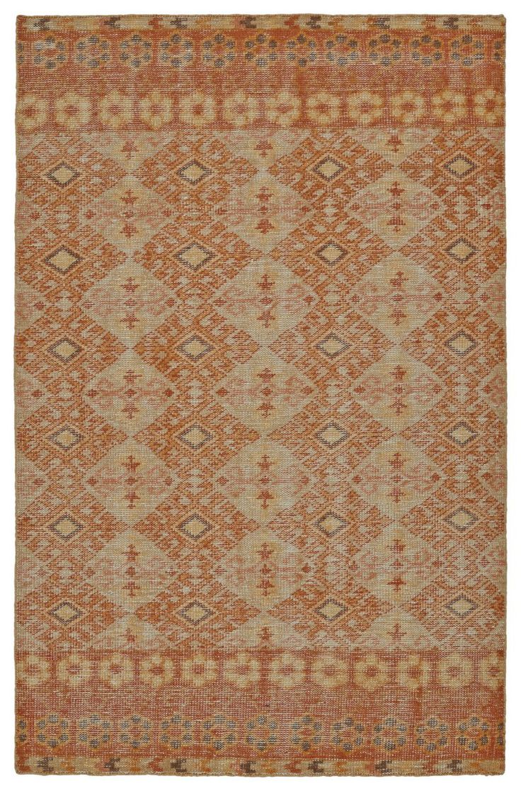 an orange and beige rug with diamond shapes