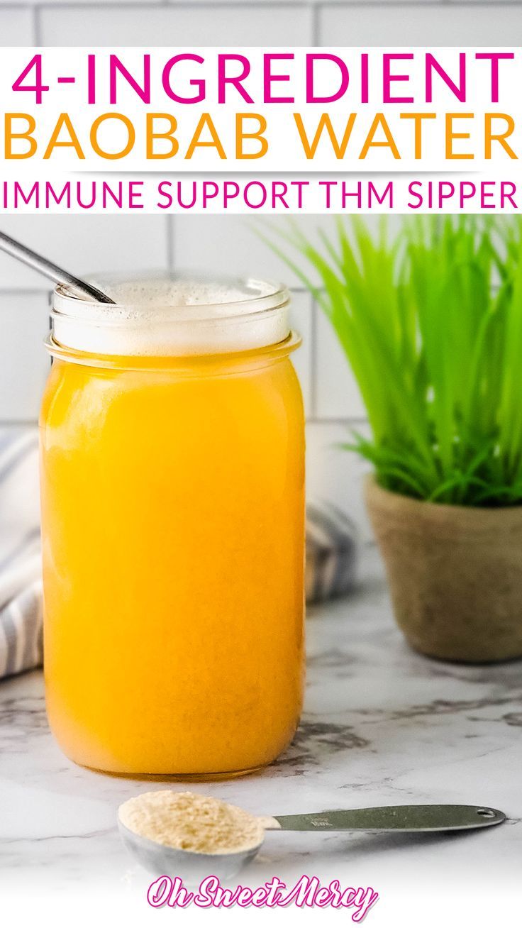 a jar filled with liquid sitting on top of a counter next to a potted plant