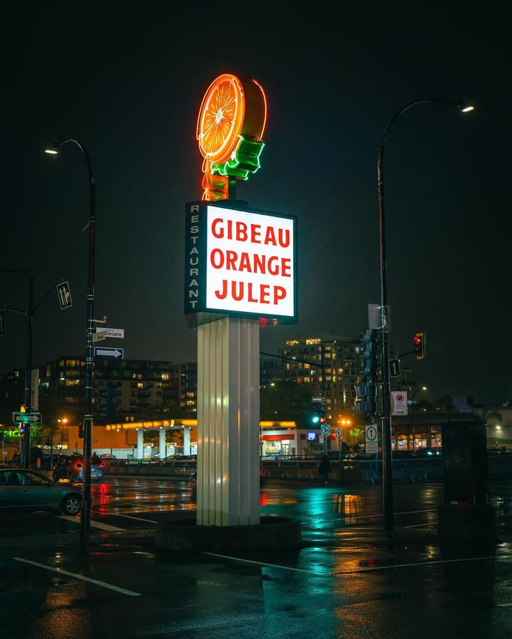 a neon sign that reads gibeu orange julep in front of a cityscape