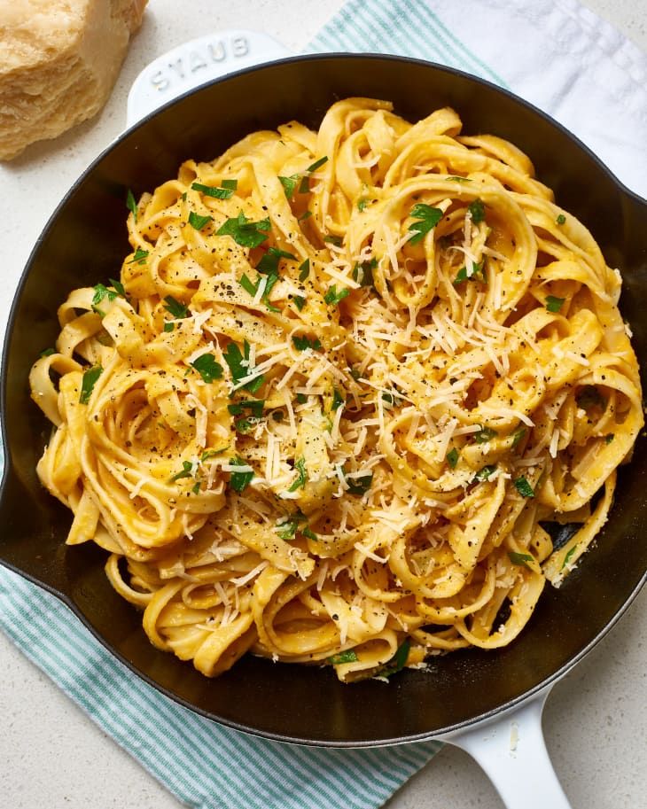 a skillet filled with pasta and parmesan cheese