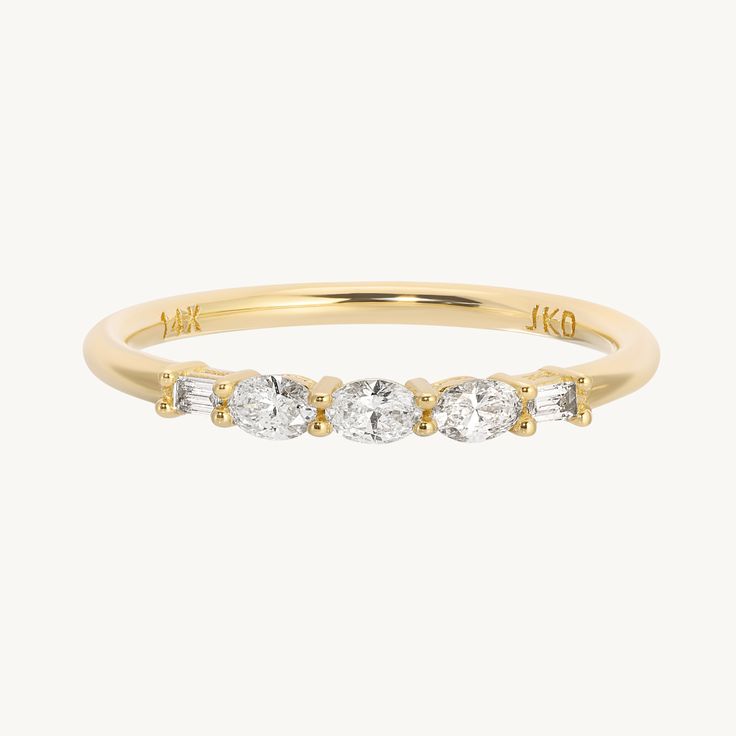 a yellow gold ring with three stones on the side and two diamonds in the middle