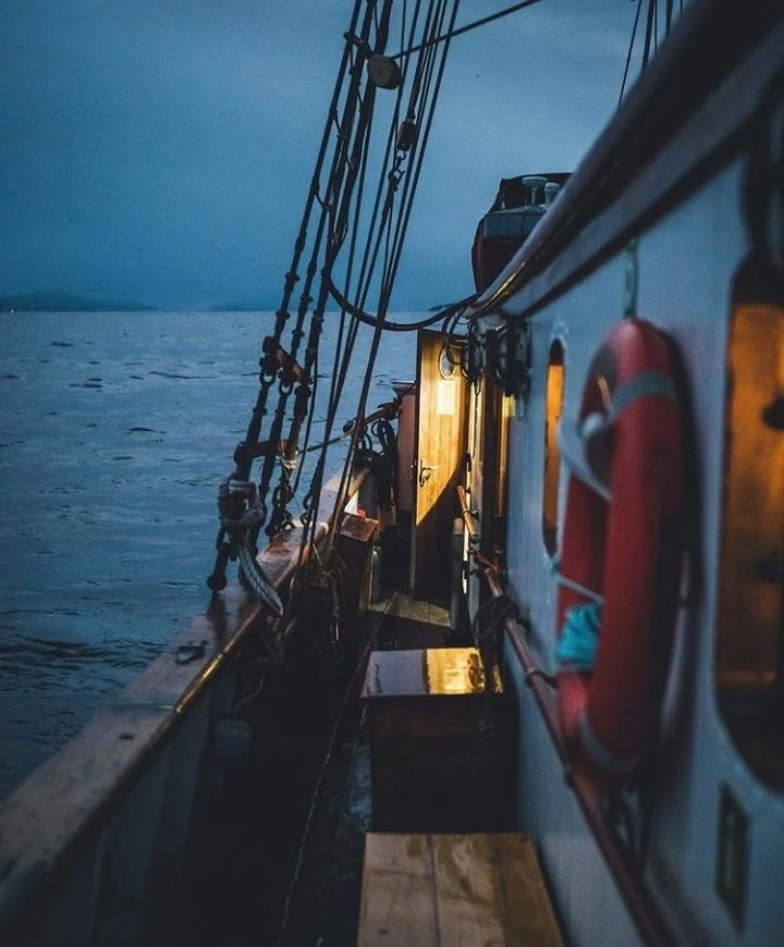 the deck of a boat at night with lights on