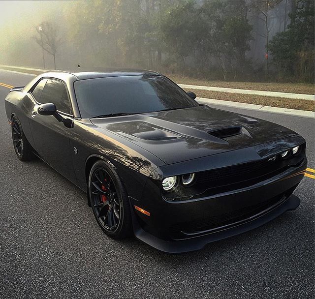 a black sports car is driving down the road