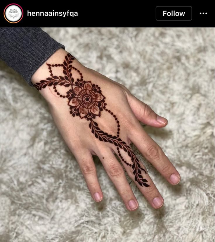 a woman's hand with henna tattoos on it