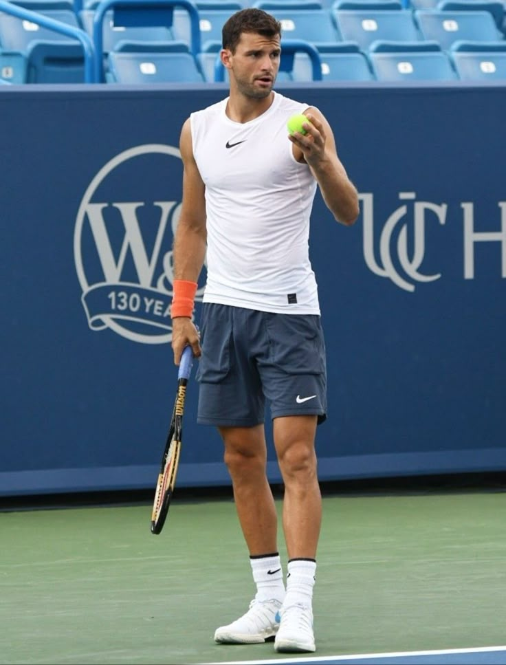 a man holding a tennis ball and racquet on a tennis court