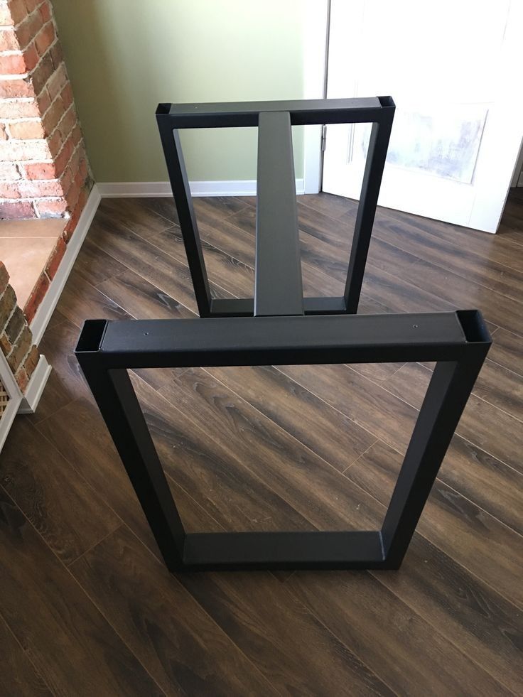 two black metal objects sitting on top of a hard wood floor