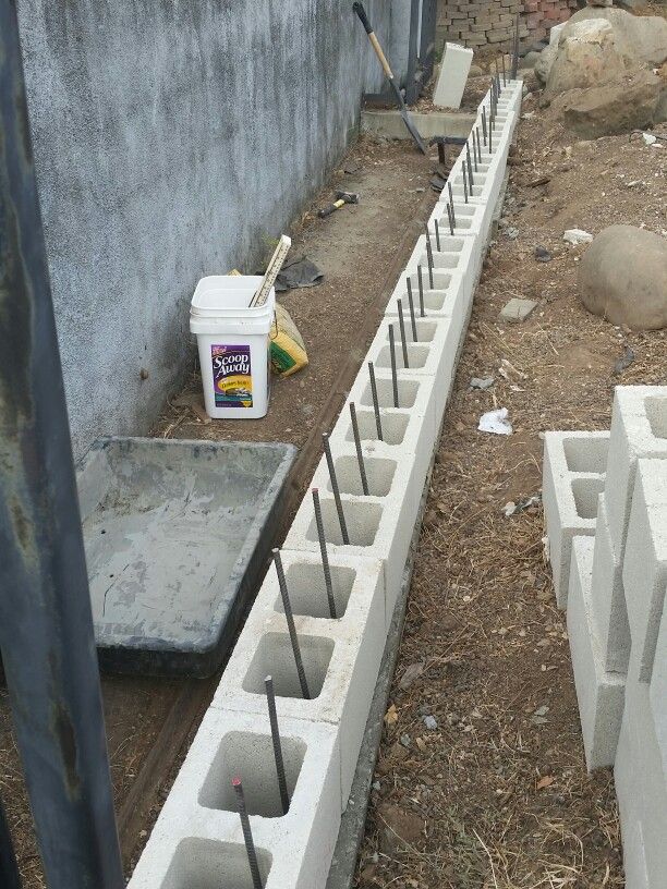 cement blocks are lined up next to each other on the ground with tools in them