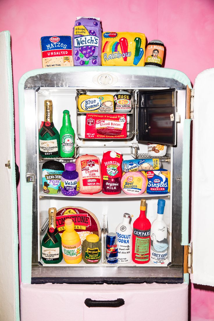 an old fashioned refrigerator is filled with condiments and other food items on display