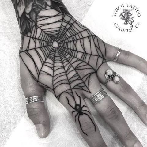 a person's hand with a spider web design on it