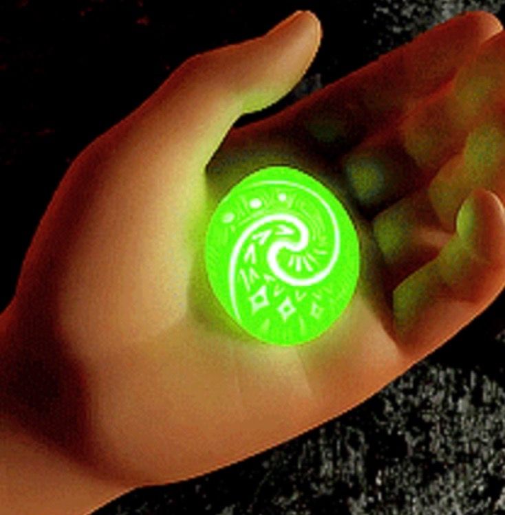 a person's hand holding a glowing green object