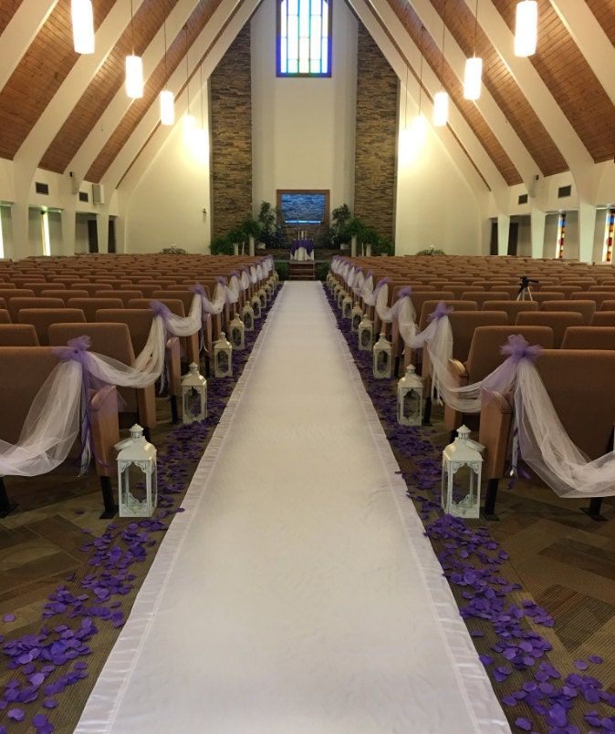 the aisle is decorated with purple and white flowers