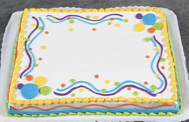 a birthday cake decorated with balloons and confetti on a white platter, ready to be eaten