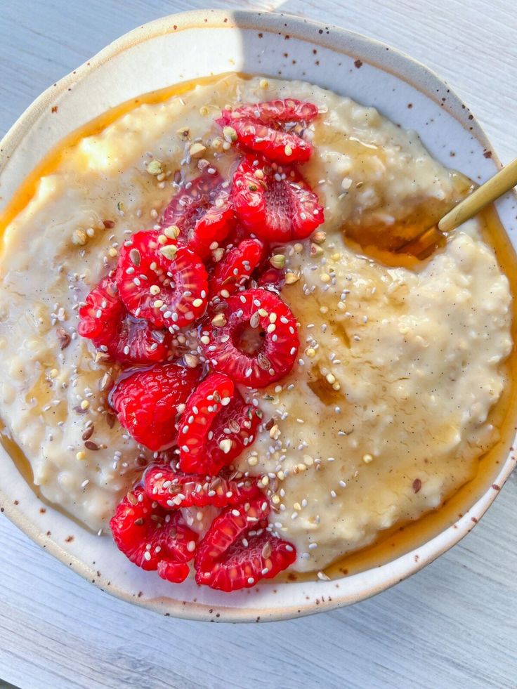 a bowl filled with oatmeal and strawberries on top of a table