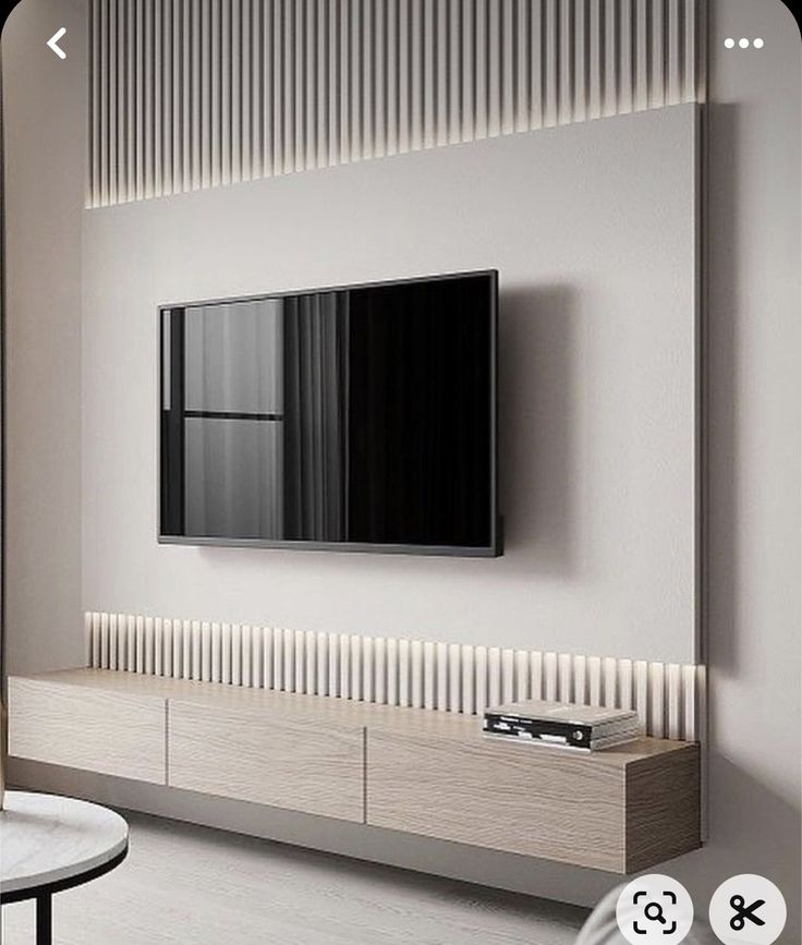 a flat screen tv mounted to the side of a white wall in a living room