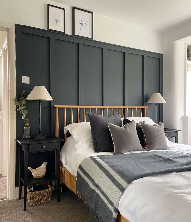 a bedroom with black paneled headboard and white bedding