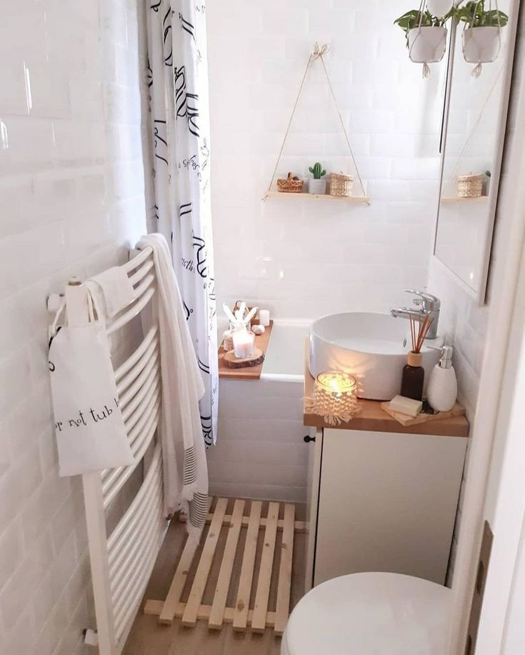 a bathroom with a toilet, sink and bathtub next to a towel rack on the wall