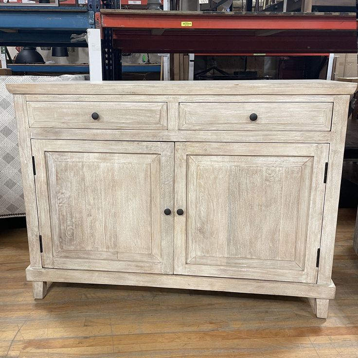 an old white wooden cabinet sitting on top of a hard wood floor in a store