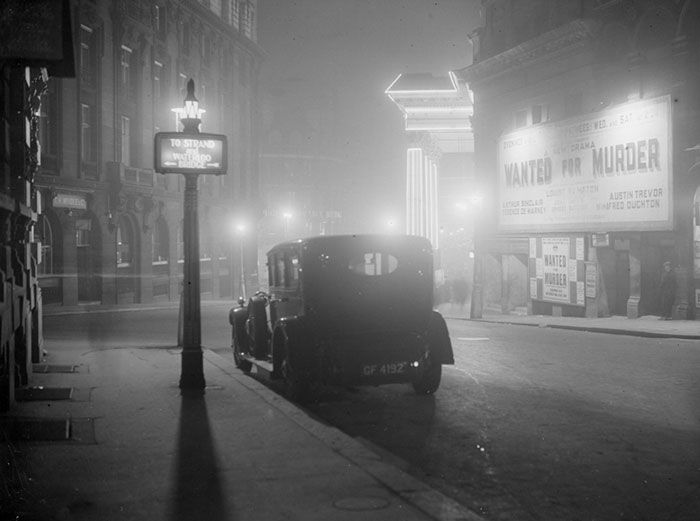 an old car is parked on the street at night