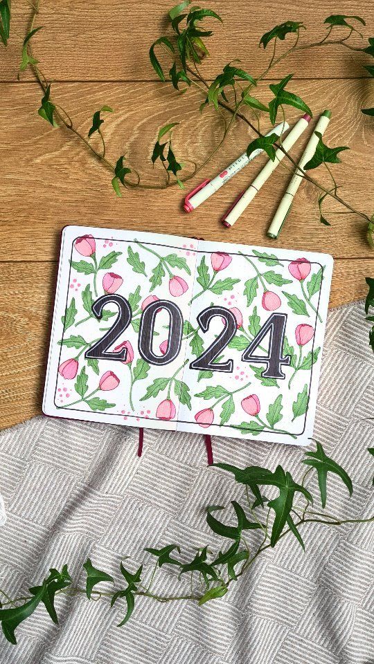 a calendar with the number twenty - four on it next to some flowers and pencils