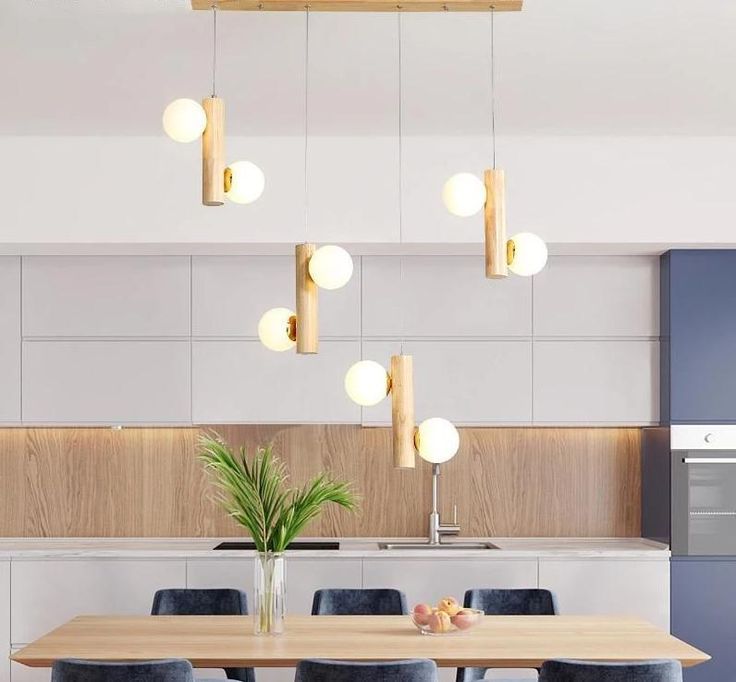 a dining room table with chairs and lights hanging from the ceiling