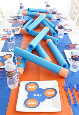 a table set up for a mickey mouse birthday party with blue and orange napkins