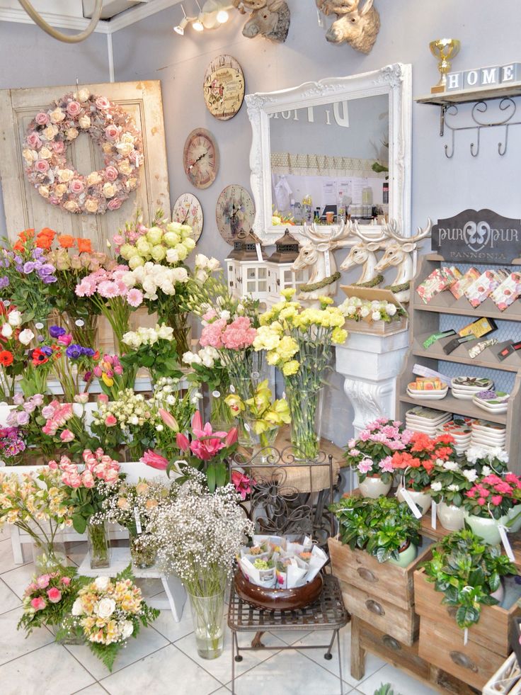 a flower shop filled with lots of different types of flowers in vases and baskets