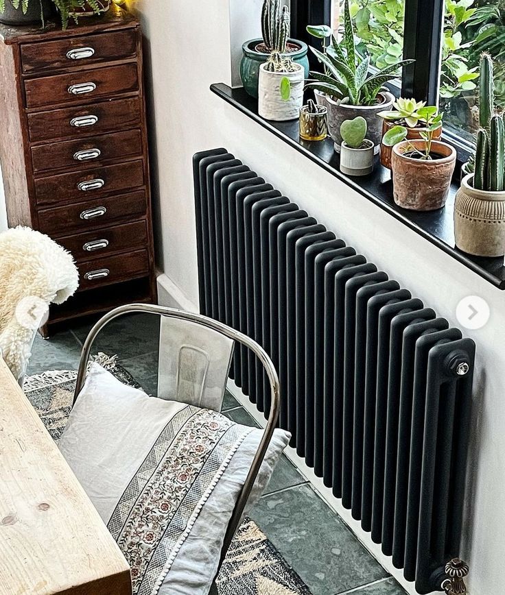 a radiator in the corner of a room with potted plants