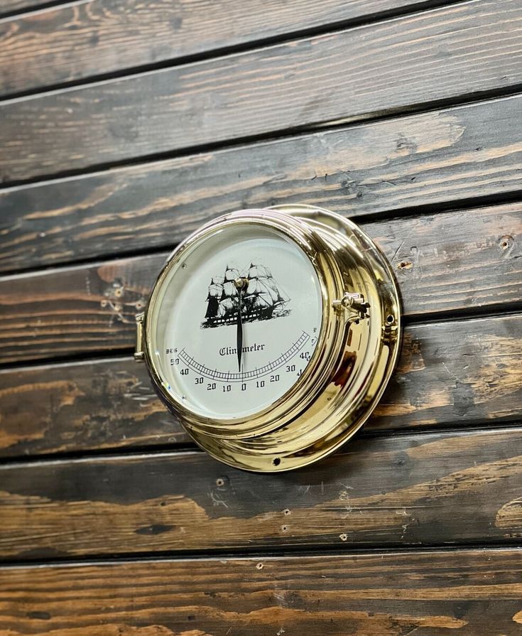 a compass mounted to the side of a wooden wall