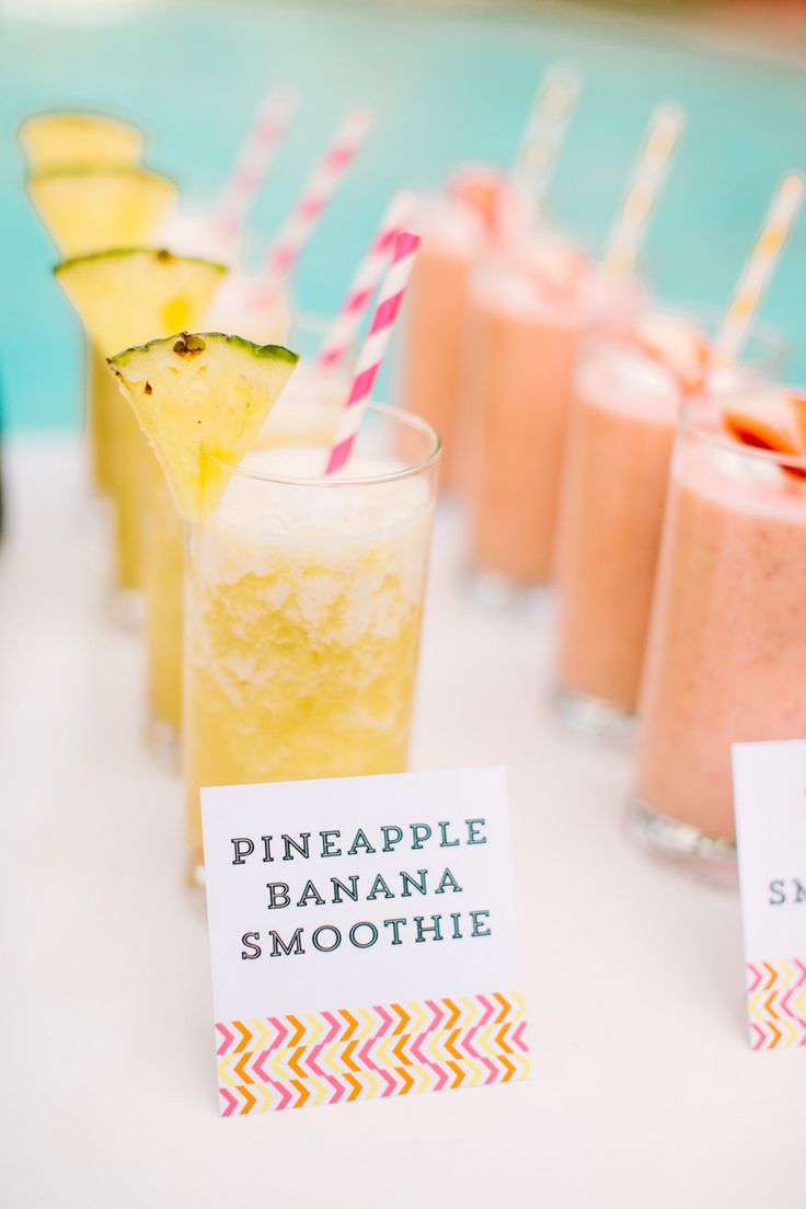 pineapple, banana and smoothie smoothies are lined up on a white table