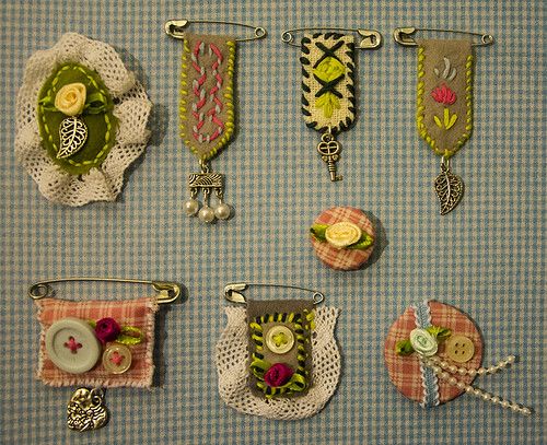 several pieces of fabric with flowers and buttons attached to them, sitting on a table