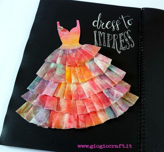 a dress made out of tissue paper sitting on top of a black notebook with the words dress to merress