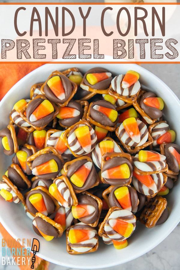 a bowl filled with candy corn pretzel bites on top of a white plate