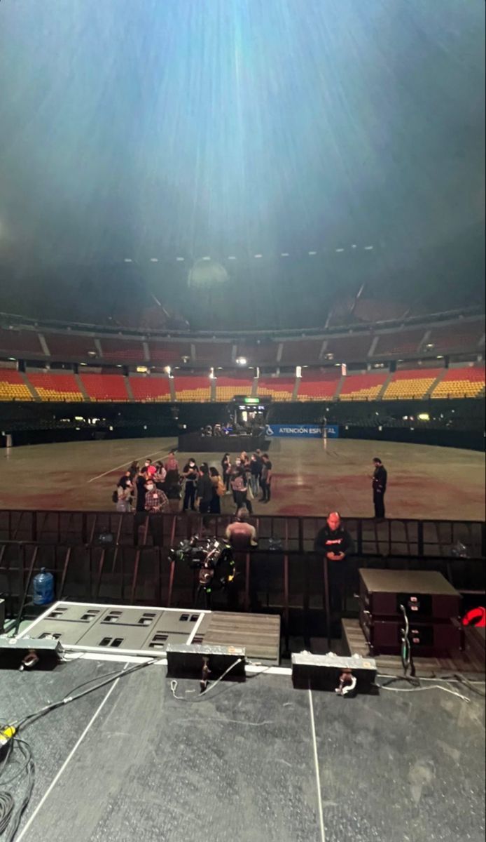 an empty stadium with people standing on the sidelines